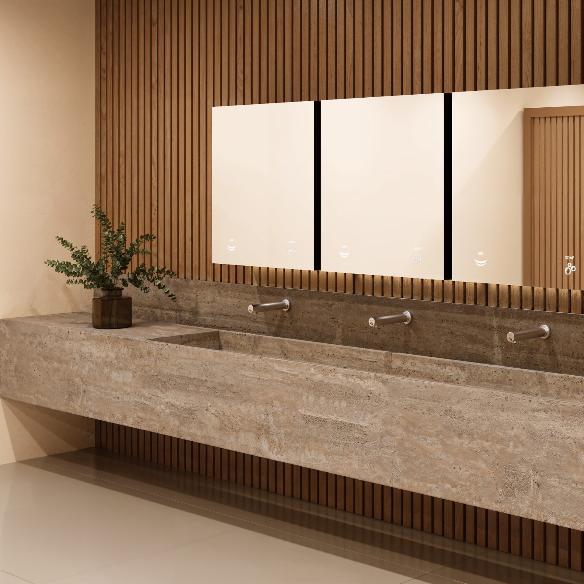 Una moderna toilette pubblica con un lungo lavandino in pietra, tre rubinetti in acciaio inox, grandi specchi, una parete di doghe di legno e una pianta in vaso sul bancone. Il design è pulito e minimalista.